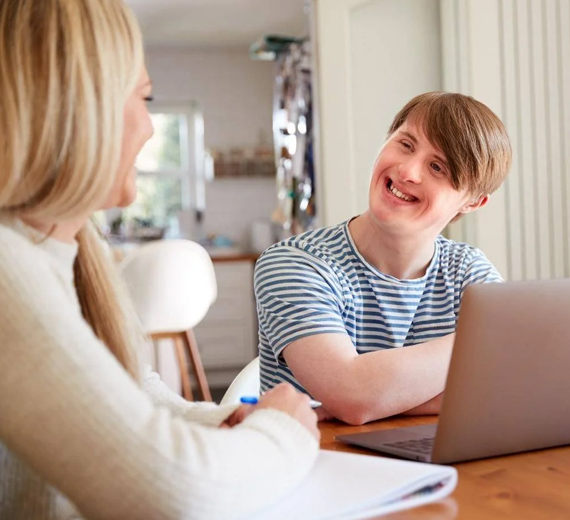 Support worker and participant collaborating on a computer